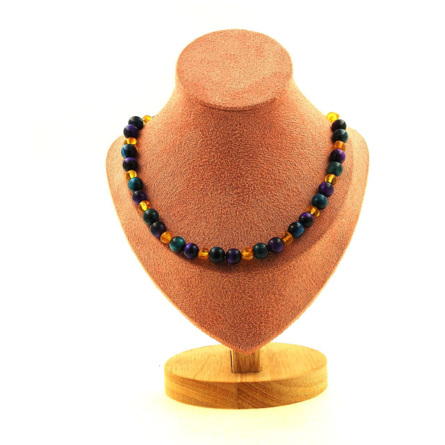 Collier artisanal en Ambre Baltique et Œil de Tigre violet/bleu — équilibre, protection et clarté spirituelle avec perles de 8 mm sur chaîne inox.
