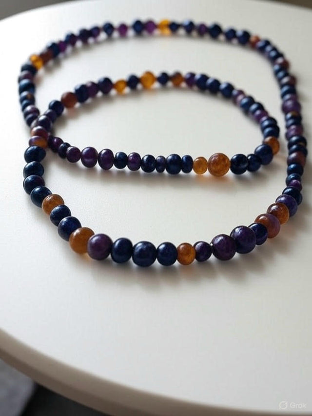 Collier fait main avec perles d'ambre et œil de tigre multicolores disposé en cercle sur fond blanc.