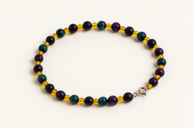 Collier fait main avec perles d'ambre et œil de tigre multicolores disposé en cercle sur fond blanc.