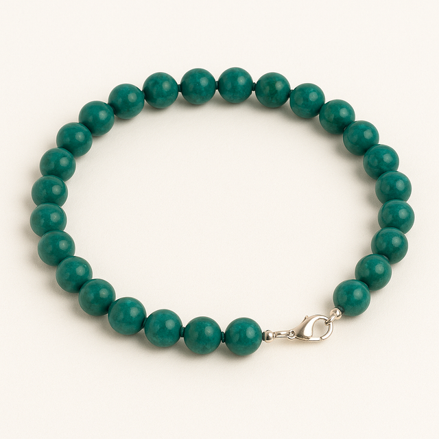 Collier en perles rondes de chrysocolle bleu-vert, disposé en cercle sur fond blanc épuré.