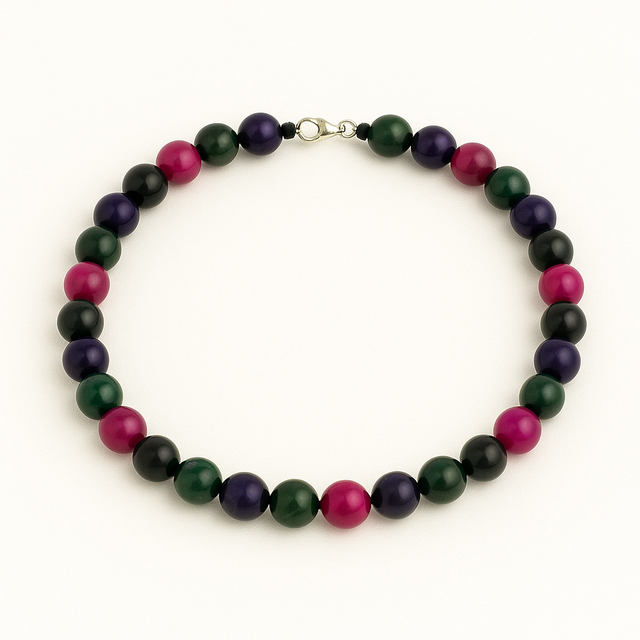 Collier en perles d'œil de tigre teinté multicolore, disposé en cercle sur fond blanc uni.